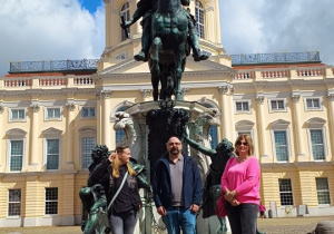 Opiekunowie wycieczki przed konnym pomnikiem Fryderyka I na dziedzińcu Pałacu Charlottenburg w Berlinie