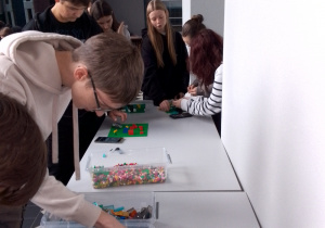 Skupieni uczestnicy warsztatów, z pasją konstruują swoje projekty z klocków LEGO
