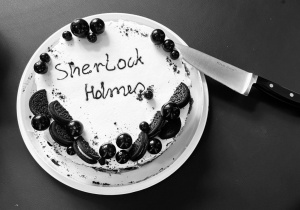 Tort tematyczny z napisem „Sherlock Holmes”, ozdobiony ciasteczkami i dekoracjami w detektywistycznym stylu, stanowił słodkie zwieńczenie wydarzenia.